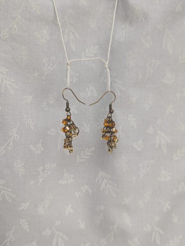 Earthy Brown beaded earrings feature four different hues of brown with various textures. Total of 12 beads per earring with 3 beads per color. Materials: glass seed beads, brass colored earring hooks, and brass colored jump rings.