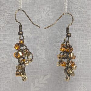 Earthy Brown beaded earrings feature four different hues of brown with various textures. Total of 12 beads per earring with 3 beads per color. Materials: glass seed beads, brass colored earring hooks, and brass colored jump rings.
