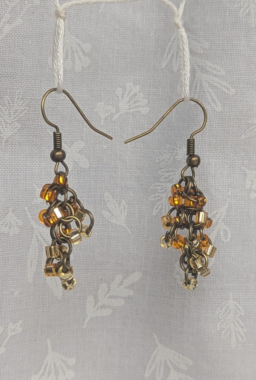 Earthy Brown beaded earrings feature four different hues of brown with various textures. Total of 12 beads per earring with 3 beads per color. Materials: glass seed beads, brass colored earring hooks, and brass colored jump rings.