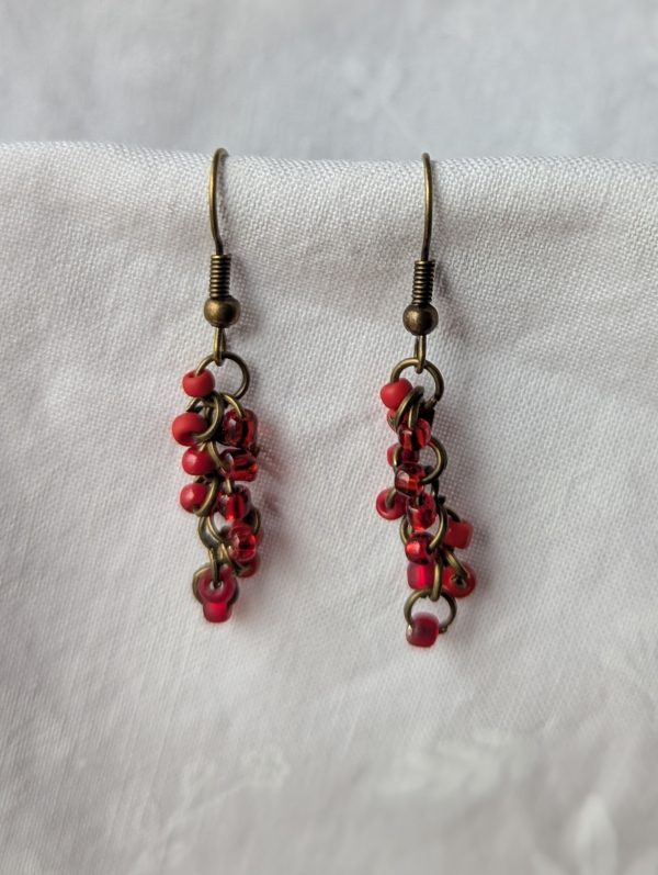 Scarlet Glow Drops: Handmade red earrings featuring six different shades of red glass seed beads, connected with bronze jump rings and matching hooks.