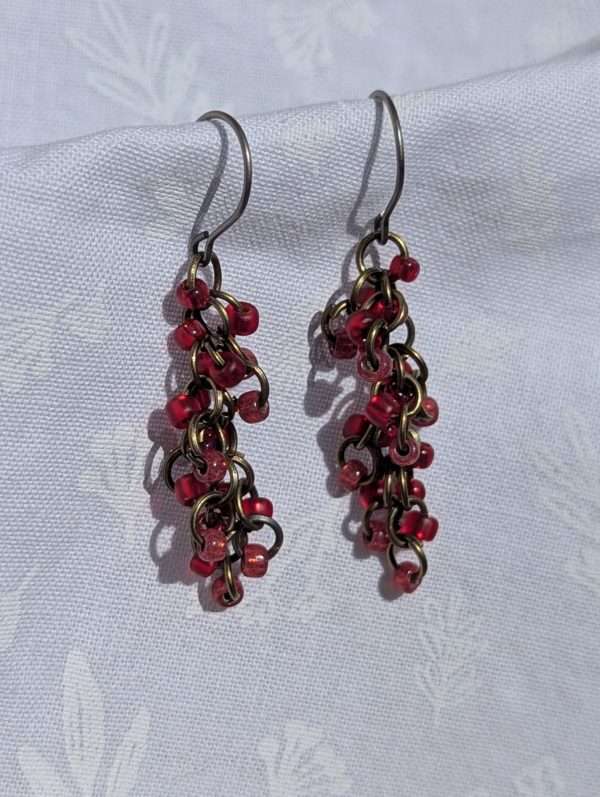 Crimson Harmony red earrings with three hues of red and various textured beads, featuring titanium hypoallergenic hooks and bronze jump rings