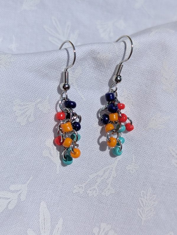 The Retro Vibes Color Block Earrings are 1970s-inspired red, yellow, light blue, and dark blue earrings with solid colors, featuring silver-colored jump rings and earring hooks.