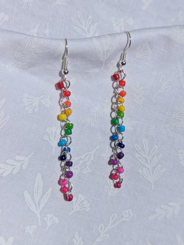 The Prismatic Flow Earrings: Vibrant rainbow gradient earrings with 14 colorful beads, featuring silver-colored jump rings and earring hooks.