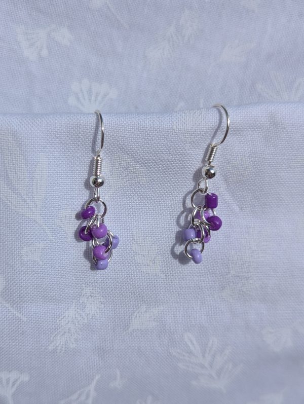 These elegant purple drops earrings feature nine purple glass seed beads per earring in three shades.