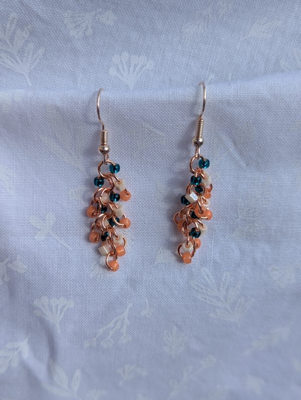 These vibrant Seaside Blossom Earrings feature a stunning blend of teal, pink, and cream glass seed beads with a variety of textures.