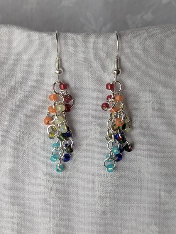 Handmade Gilded Prism Earrings featuring 18 pearly and metallic-lined glass beads in red, orange, yellow, green, deep blue, and capri blue, with silver-colored jump rings and hooks.