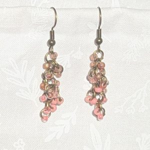 Caption: Blushed Bronze – Handmade dangle earrings featuring 18 beads in soft pink and mauve shades with bronze-colored jump rings and matching earring hooks.
