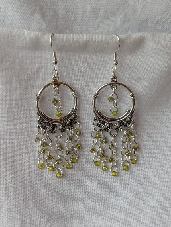 Lime Essence Chandelier Earrings with Tibetan ornaments, featuring three textures of lime green beads: green lined clear, silver-lined green, and lime-green lined green.