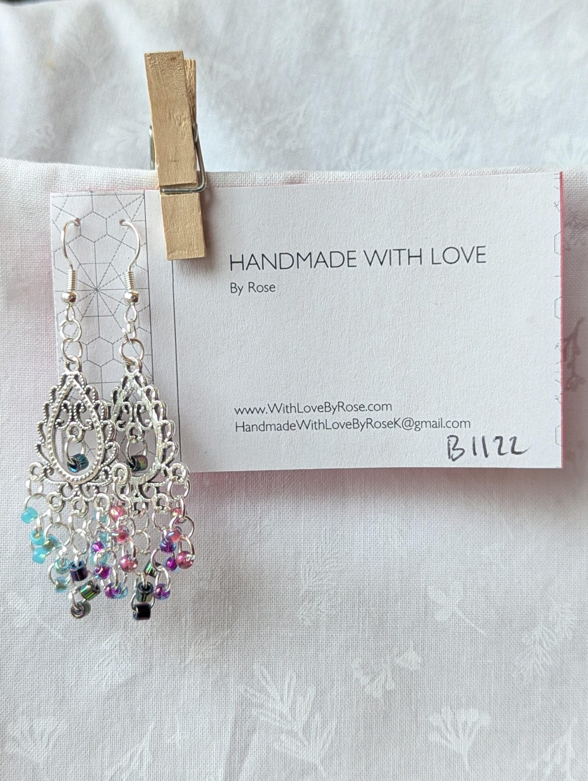 Bohemian Mermaid Earrings with Tibetan ornament, featuring 16 beads in oceanic hues including shimmering aqua blue, metallic iridescent blue, iridescent indigo, fuchsia-lined blue, and pink-lined clear.