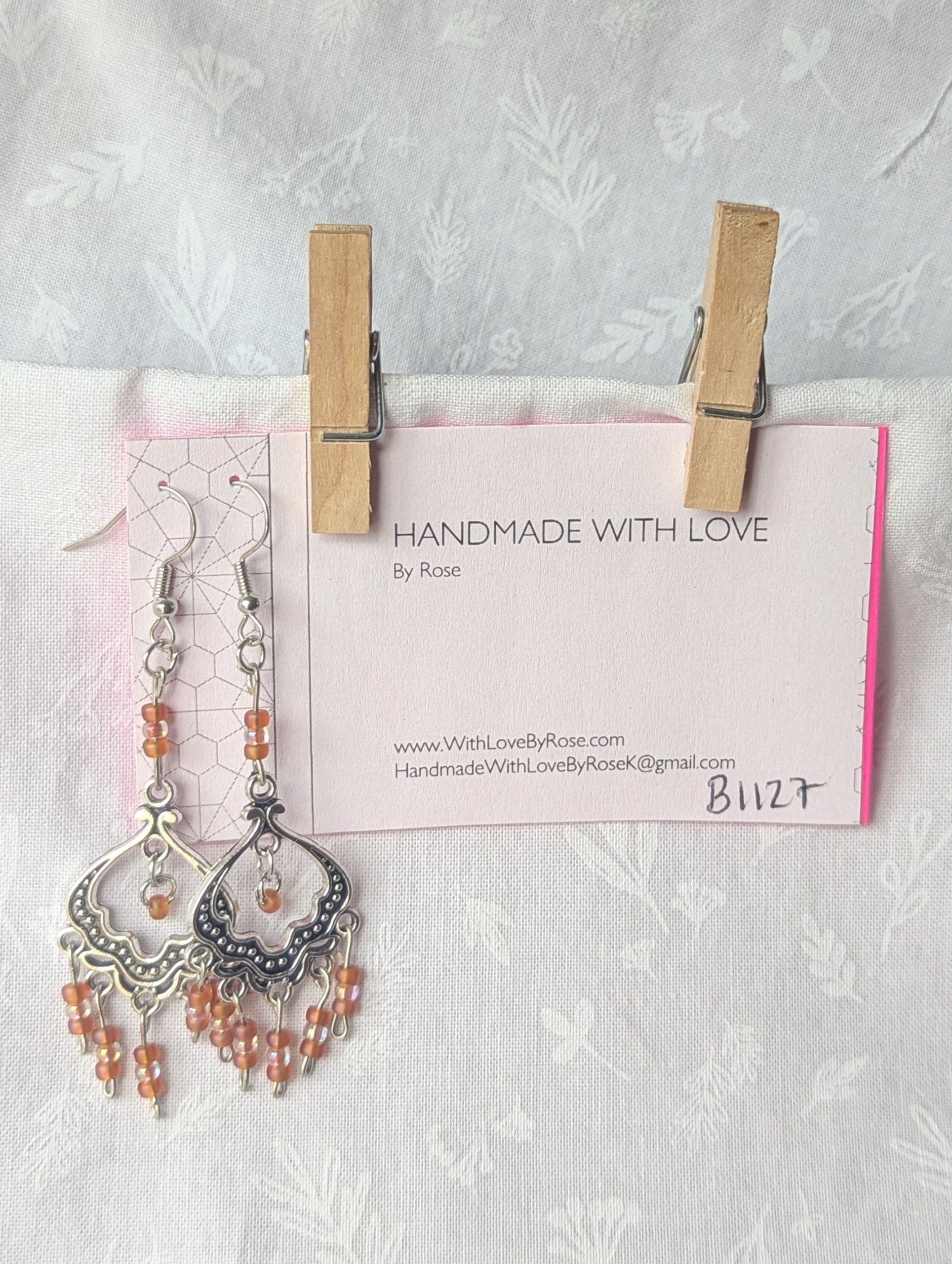 Blushing Elegance Chandelier Earrings feature a Tibetan ornament and 19 beads in frosted iridescent ballet pink and pale pink-lined clear.