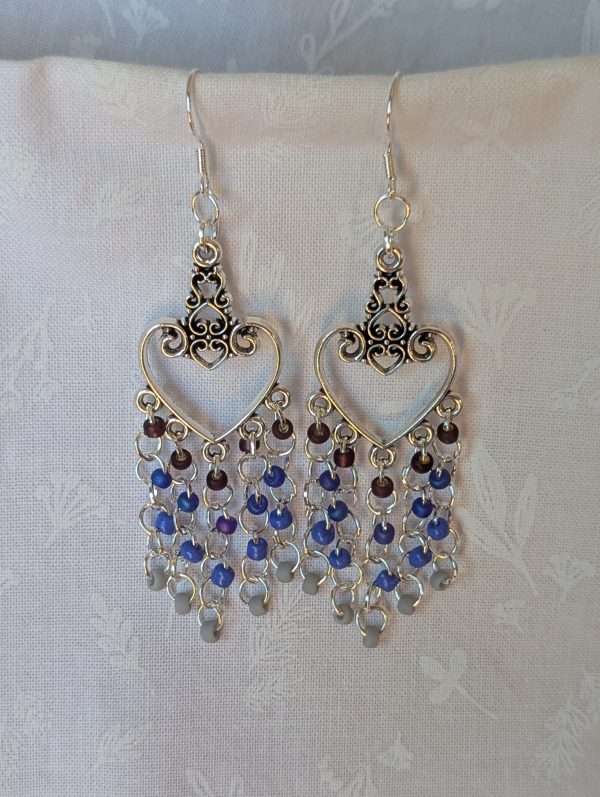 Twilight Romance Earrings: Pair of silver-colored heart earrings with intricate filigree tops and 20 dangling glass beads in deep red, blue, violet-blue, and frosted gray.