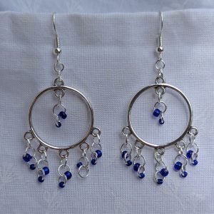 The Celestial Mobile Earrings: a pair of silver-colored hoop earrings with dangling silver jump rings and blue shiny glass beads