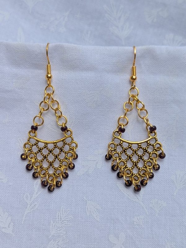 Gilded Wine Earrings: Gold-colored earrings with 11 burgundy red glass beads featuring gold lining, hung from antique gold ornaments.