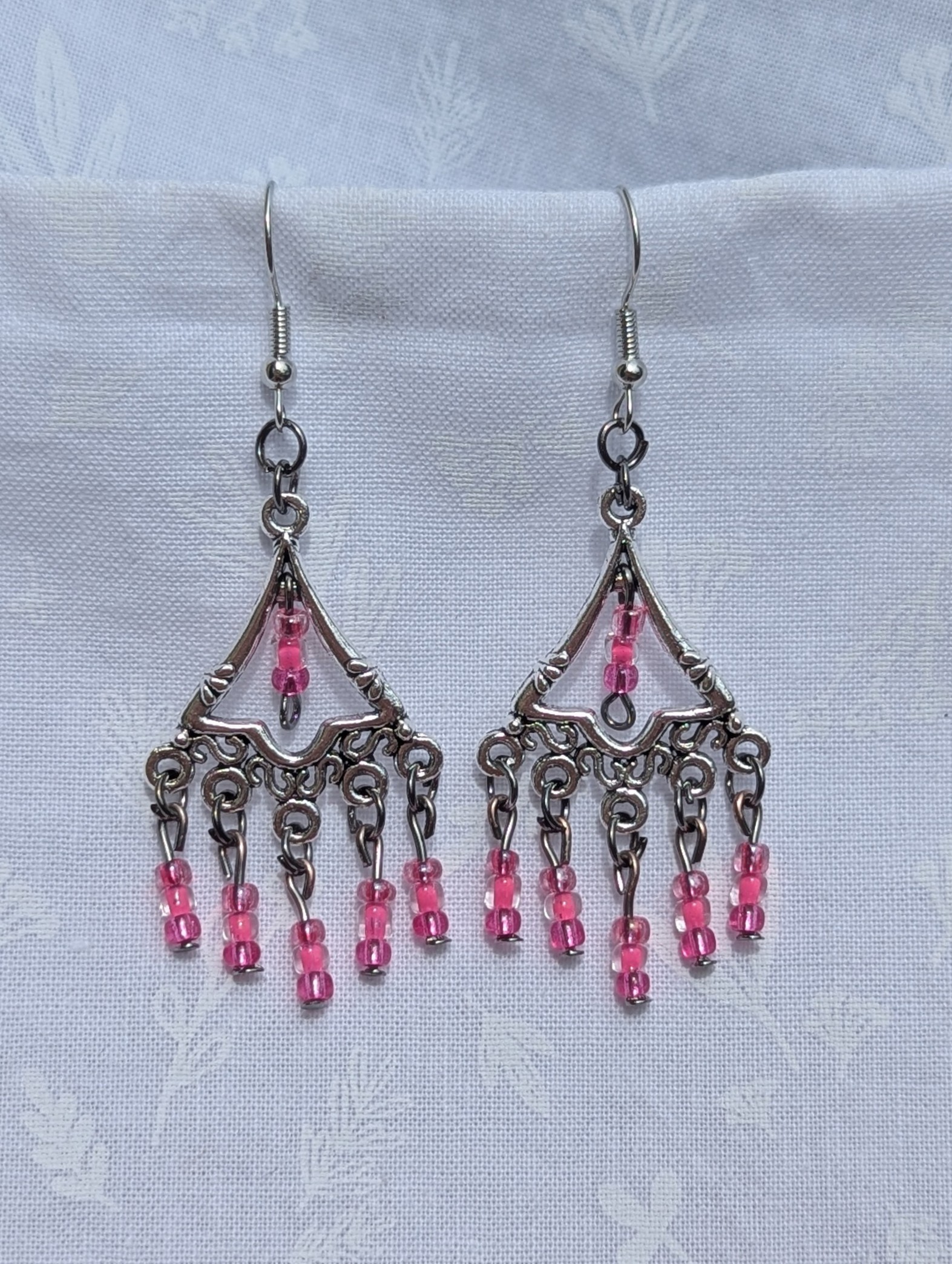 Impatiens Bloom Earrings: Silver triangular earrings with 18 pink impatiens-colored glass beads in pearly and translucent finishes, accented with tungsten and silver hardware.