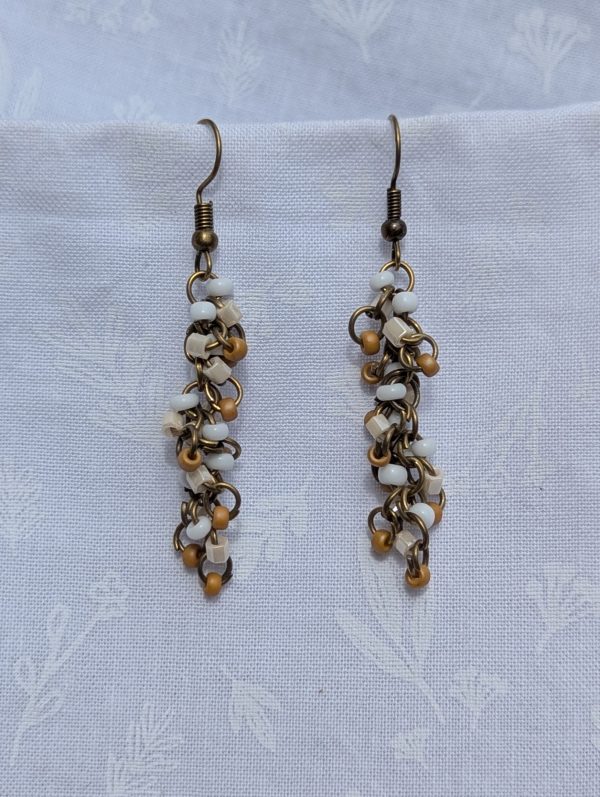Sandswept Cascade Earrings: Earrings with earthy tan, ivory white, and pearlescent cream glass beads on bronze-toned jump rings with matching hooks.