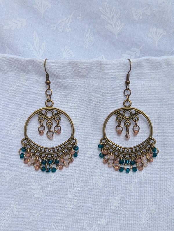 Twilight Oasis — Bronze Tibetan-style earrings with 25 glass beads in frosted teal, silver-lined teal, pale pink, and rose pink.
