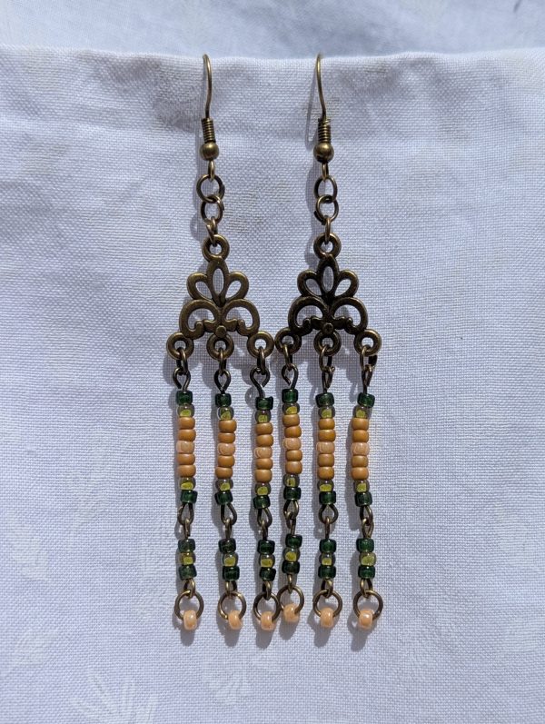 Verdant Bloom — Bronze chandelier earrings with floral Tibetan-style ornaments and dangling strands of amber, forest green, pale yellow, and ivory glass beads.