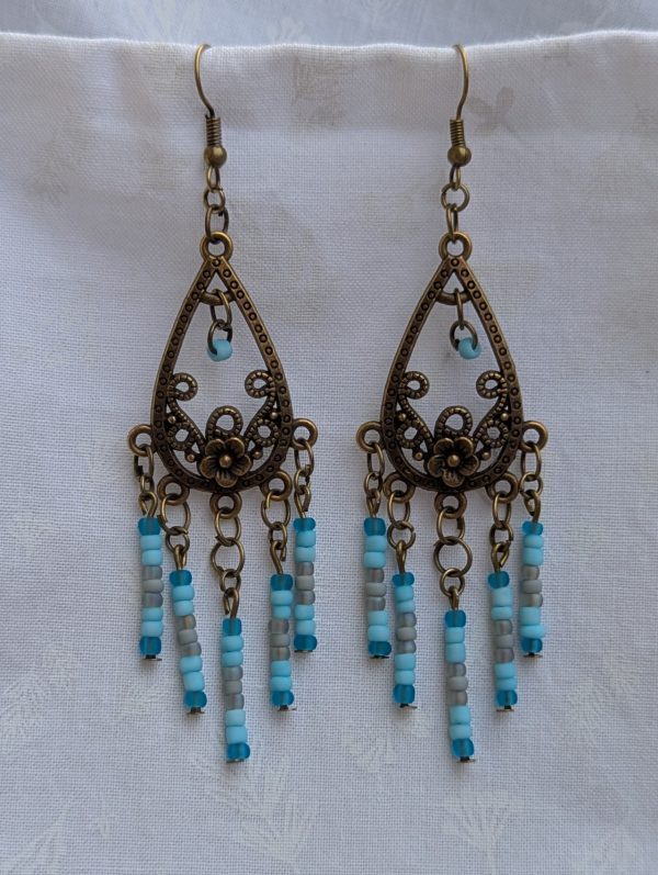 Winter Garden Earrings — Bronze teardrop earrings with floral filigree and dangling strands of glacier blue, sky blue, gray, and turquoise glass beads.