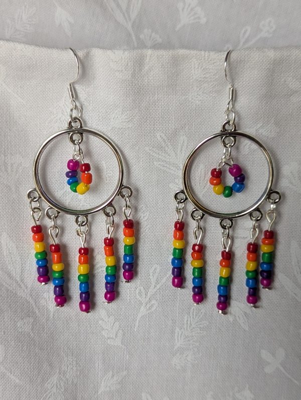 Rainbow circle earrings with silver hoops, five dangling rainbow strands, and a circular rainbow bead charm in the center.