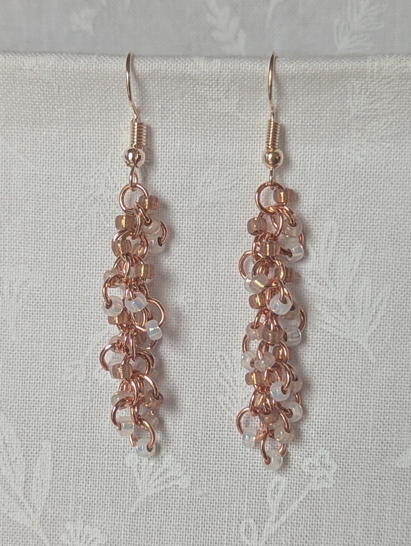 Rosy Lumina Earrings with 27 blush pink, pearly white, and translucent rose beads on copper jump rings with rose-gold earring hooks.