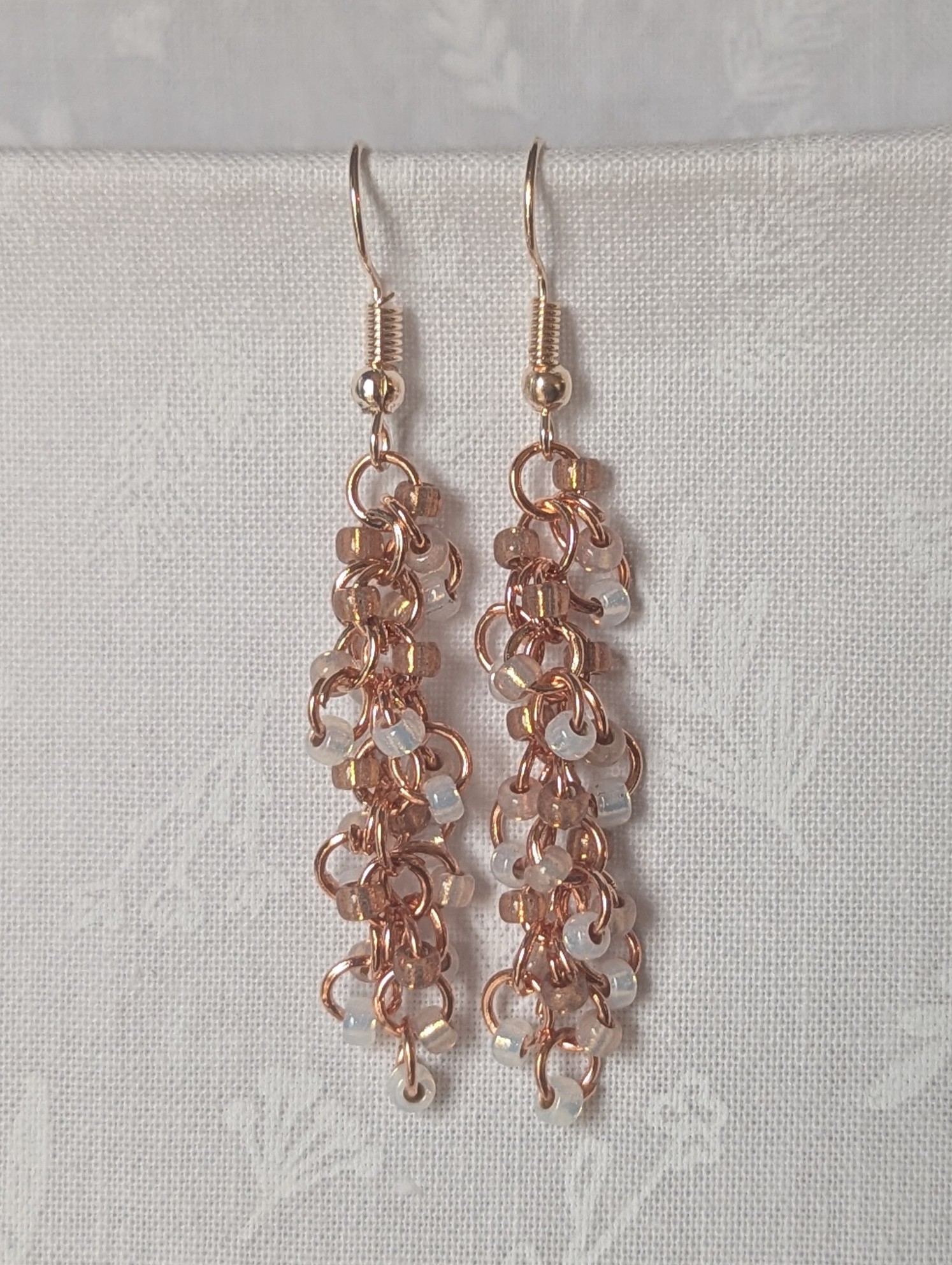 Rosy Lumina Earrings with 27 blush pink, pearly white, and translucent rose beads on copper jump rings with rose-gold earring hooks.