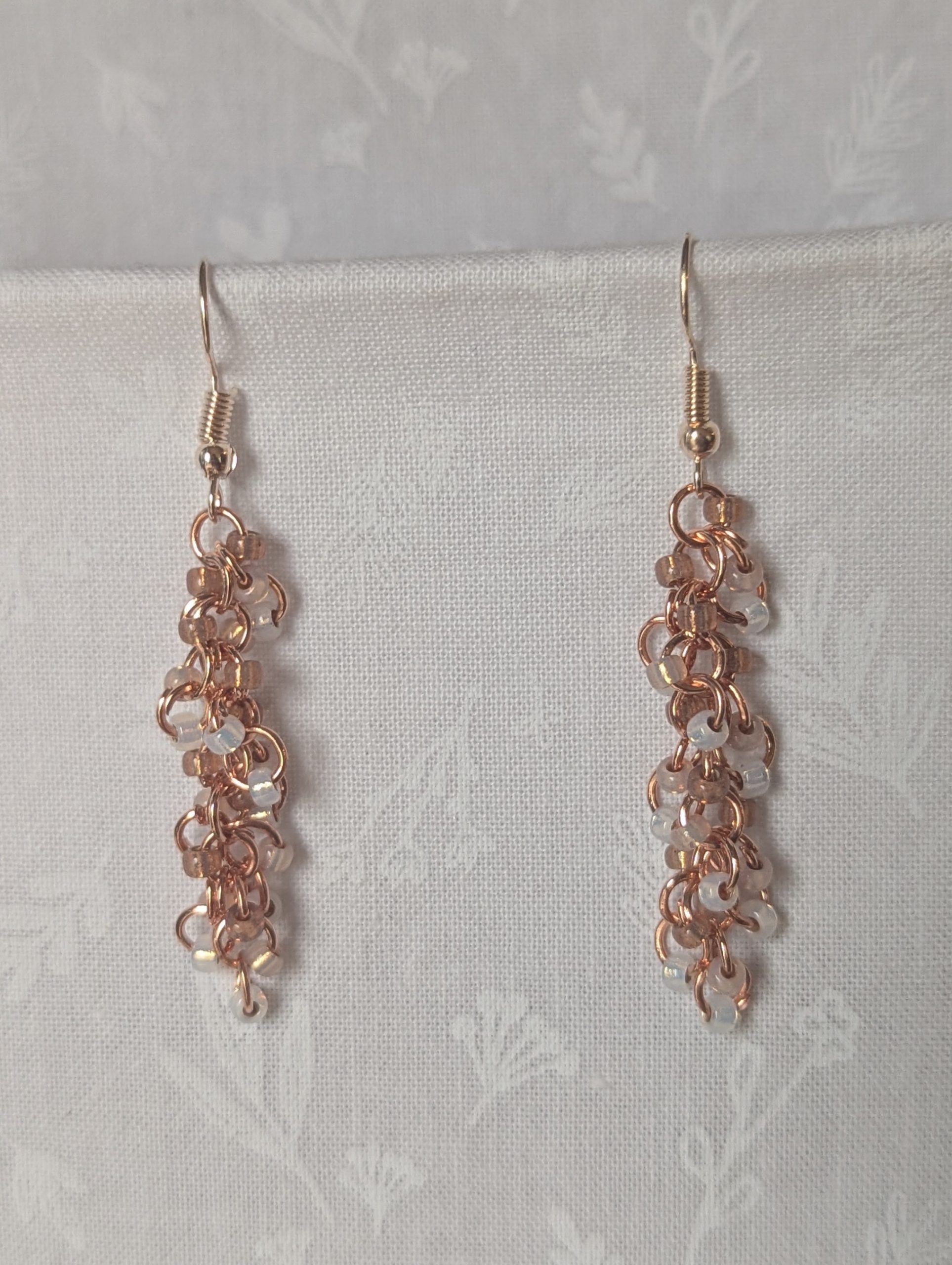 Rosy Lumina Earrings with 27 blush pink, pearly white, and translucent rose beads on copper jump rings with rose-gold earring hooks.