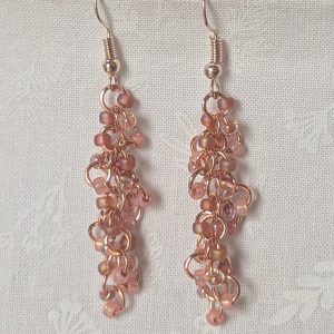 Blush Bloom Earrings with 27 soft pink glass beads in matte, translucent, and iridescent finishes, on copper rings with rose-gold earring hooks.
