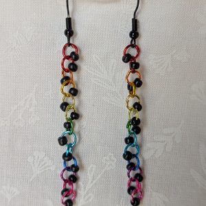 Dark Prism Earrings featuring 13 matte black beads and rainbow-colored jump rings from red to pink, hanging from black earring hooks.