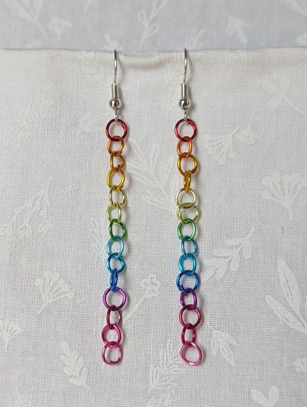 Spectrum Sleek Earrings made with 14 rainbow-colored jump rings, arranged in a smooth gradient and hung from polished steel-colored hooks.