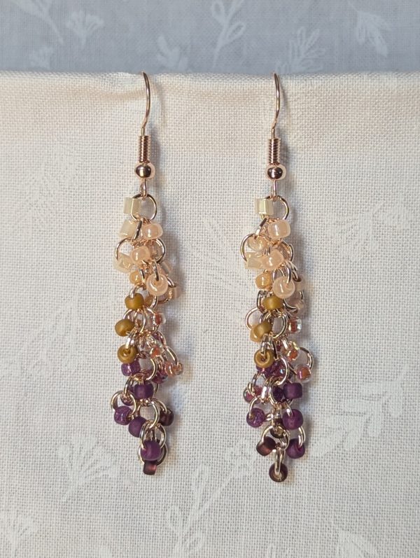 Handmade Twilight Garden earrings featuring 30 gradient beads from cream to purple on rose-gold jump rings with matching hooks.