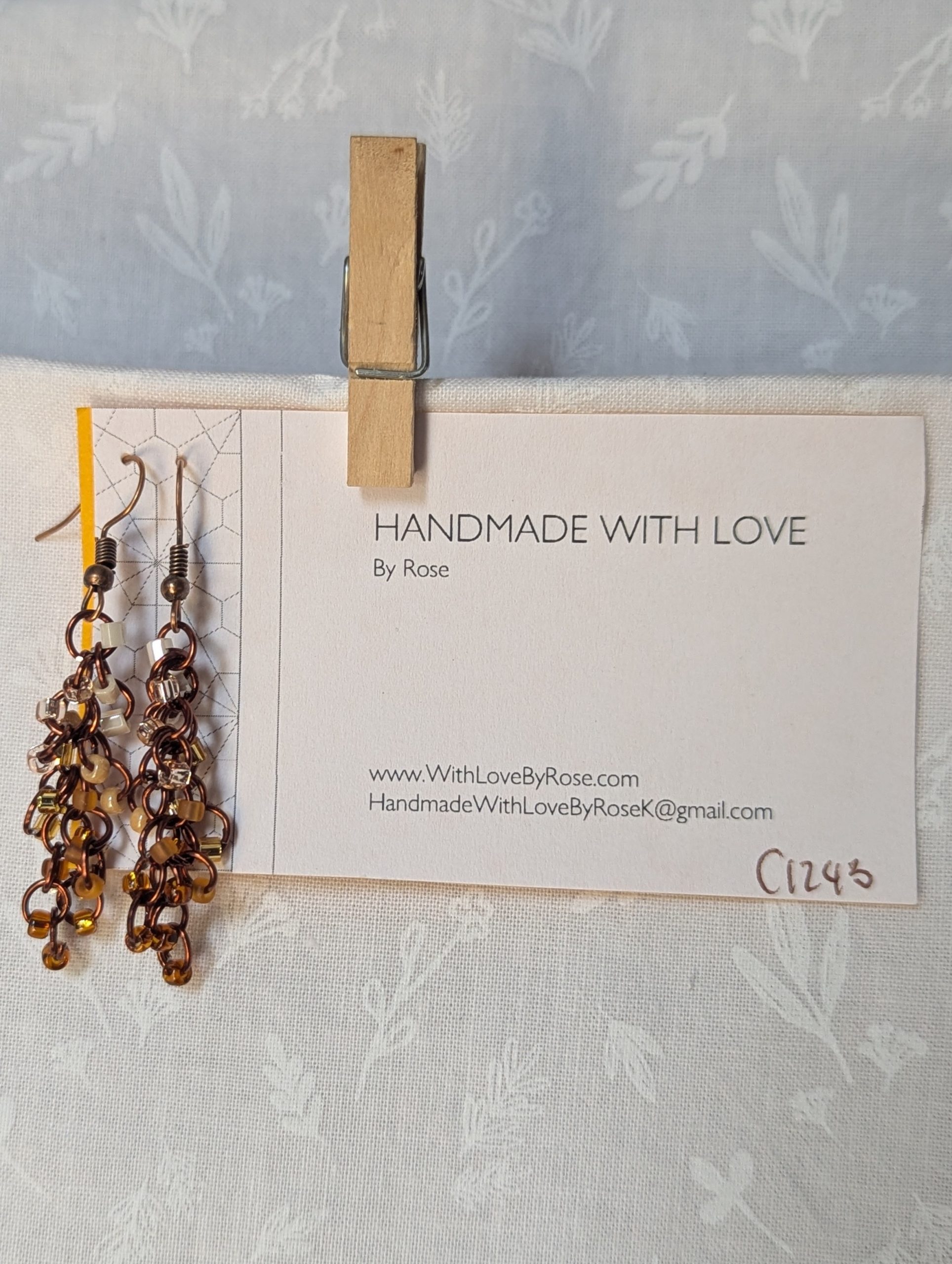 Handmade earrings with 21 gradient cream-to-brown beads on brown jump rings and antique bronze hooks.