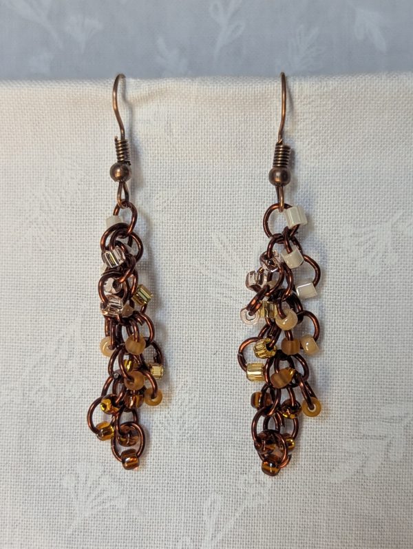 Handmade earrings with 21 gradient cream-to-brown beads on brown jump rings and antique bronze hooks.