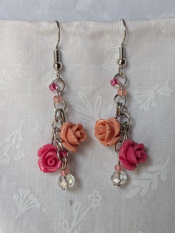 Handmade blush rose cascade earrings with coral and pink roses, glass seed beads, and crystal accents on steel colored hooks.