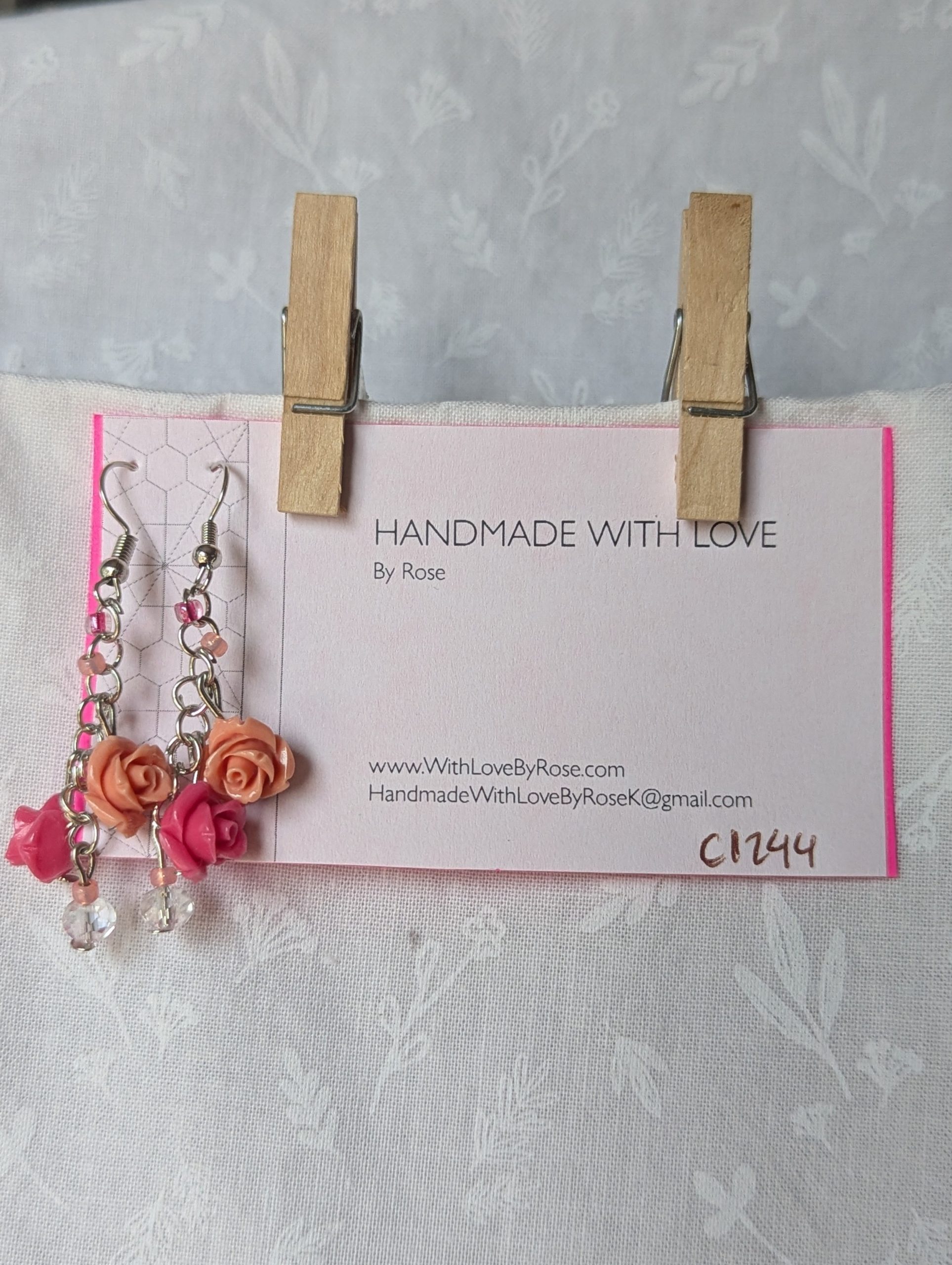 Handmade blush rose cascade earrings with coral and pink roses, glass seed beads, and crystal accents on steel colored hooks.