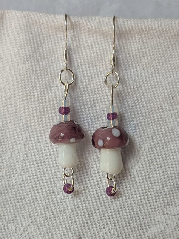 Handmade purple mushroom earrings with glass toadstools, purple and white seed beads, and sterling silver hooks.
