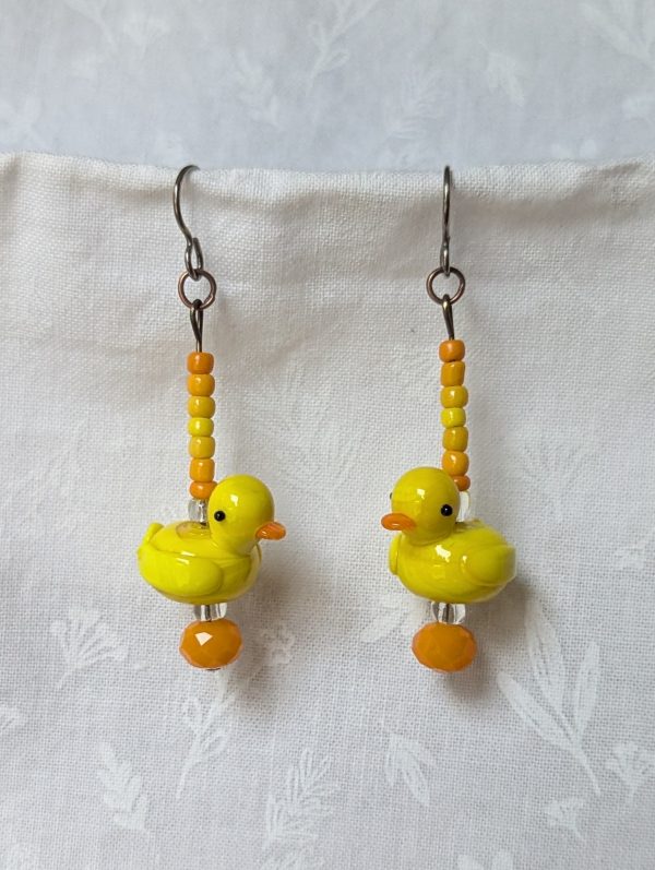 Handmade duck earrings with yellow glass duck beads, orange and yellow seed beads, Czech orange bead, and clear accents on titanium hooks.