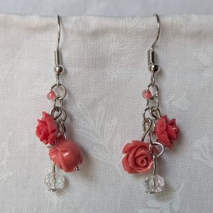 Handmade blooming rose earrings with coral and pink roses, glass seed beads, and crystal accents on steel colored hooks.