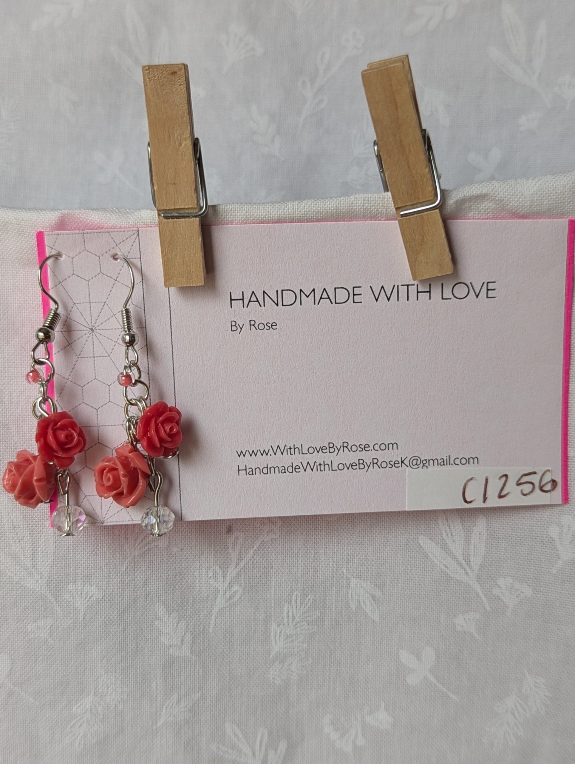Handmade blooming rose earrings with coral and pink roses, glass seed beads, and crystal accents on steel colored hooks.