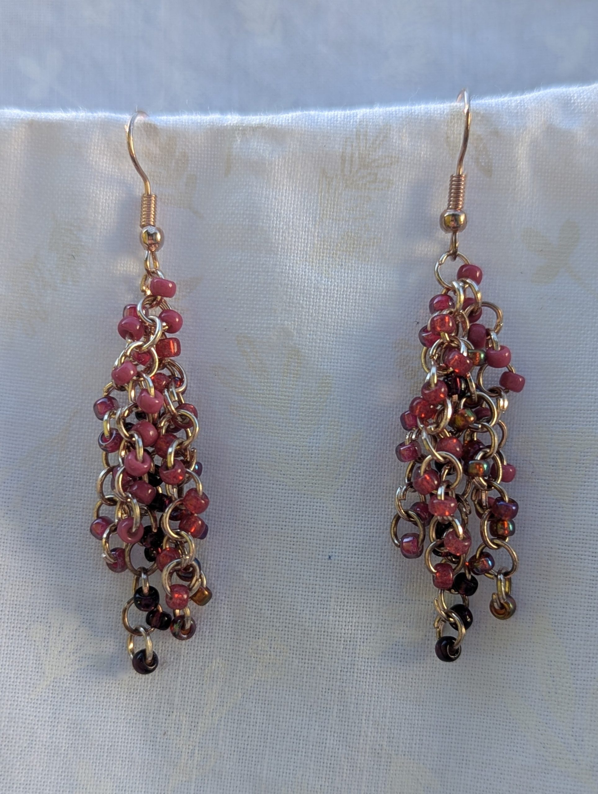Handmade pink beaded earrings with 45 glass seed beads in deep pink shades, linked with rose-gold jump rings and hooks.