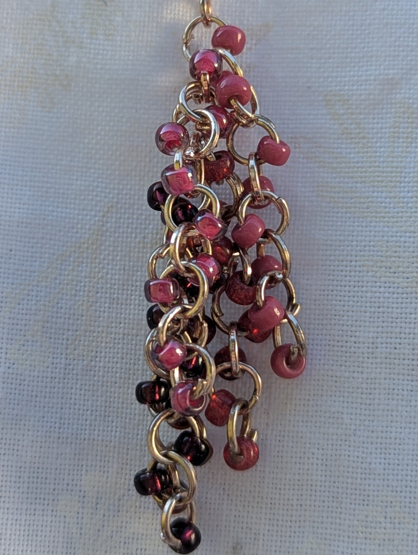 Handmade pink beaded earrings with 45 glass seed beads in deep pink shades, linked with rose-gold jump rings and hooks.