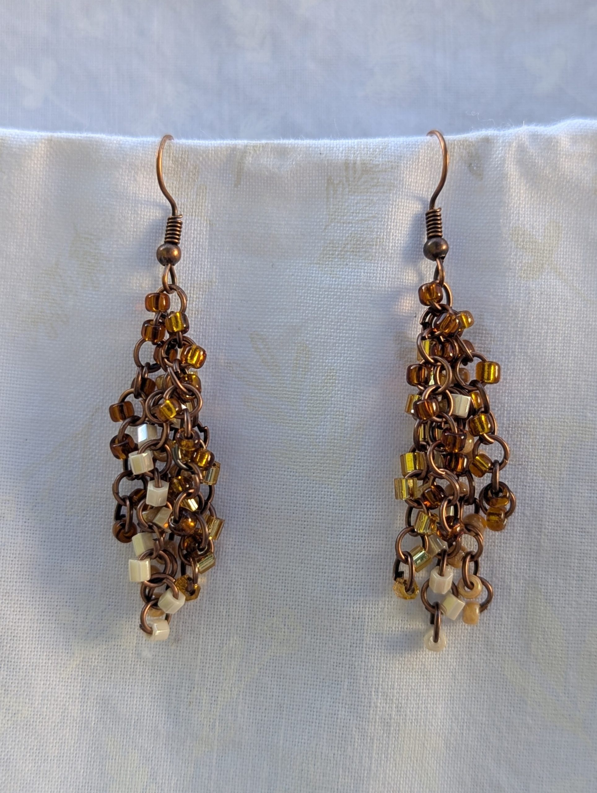 Autumn Cascade Earrings: Handmade brown beaded earrings with 45 glass beads in warm fall shades of amber, cream, bronze, and espresso.