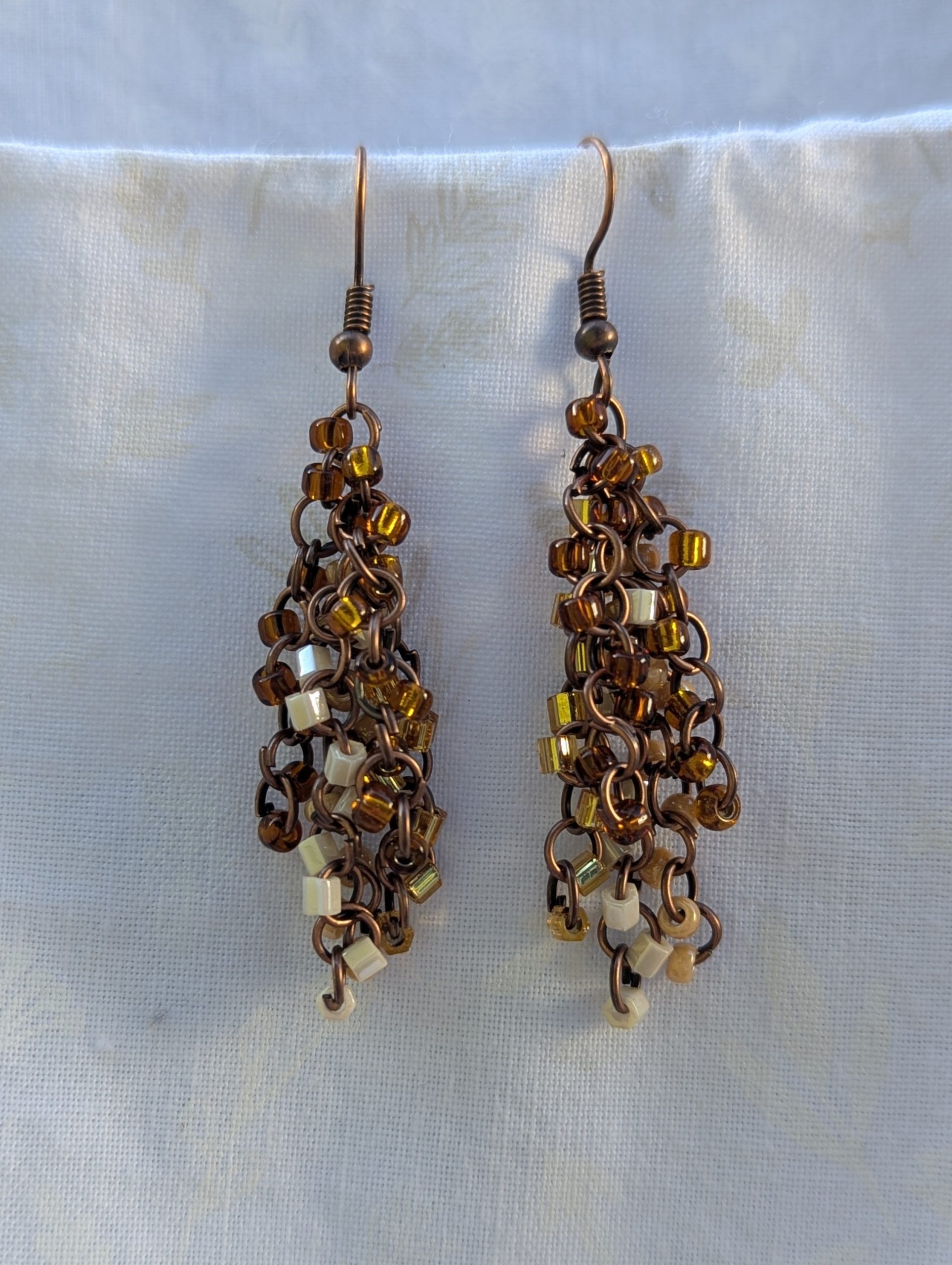 Autumn Cascade Earrings: Handmade brown beaded earrings with 45 glass beads in warm fall shades of amber, cream, bronze, and espresso.