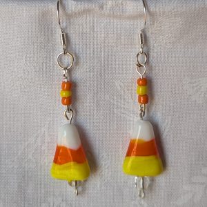 Handmade candy corn earrings with glass charms in yellow, orange, and white, accented by orange and yellow glass seed beads on sterling silver hooks.