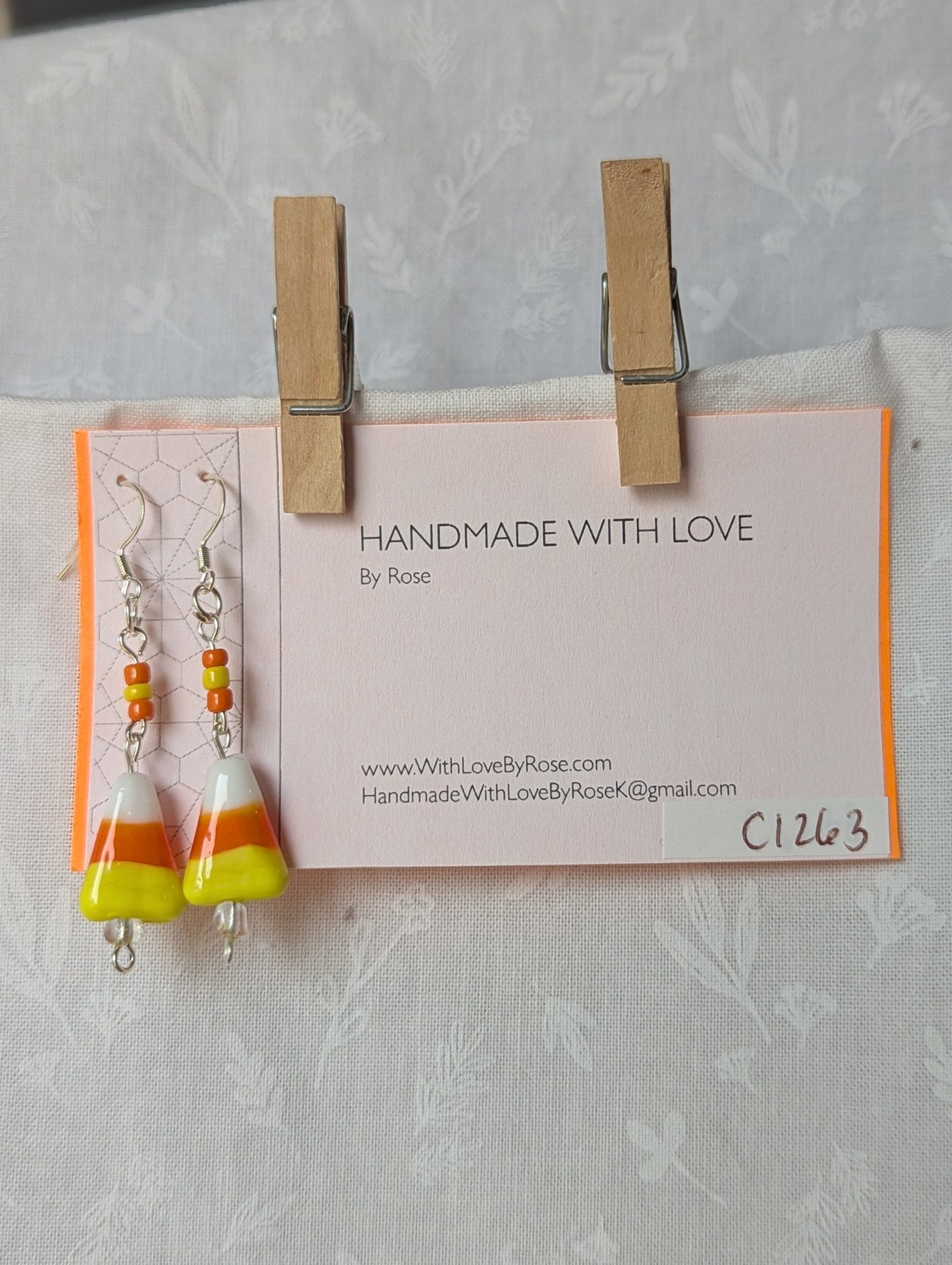Handmade candy corn earrings with glass charms in yellow, orange, and white, accented by orange and yellow glass seed beads on sterling silver hooks.