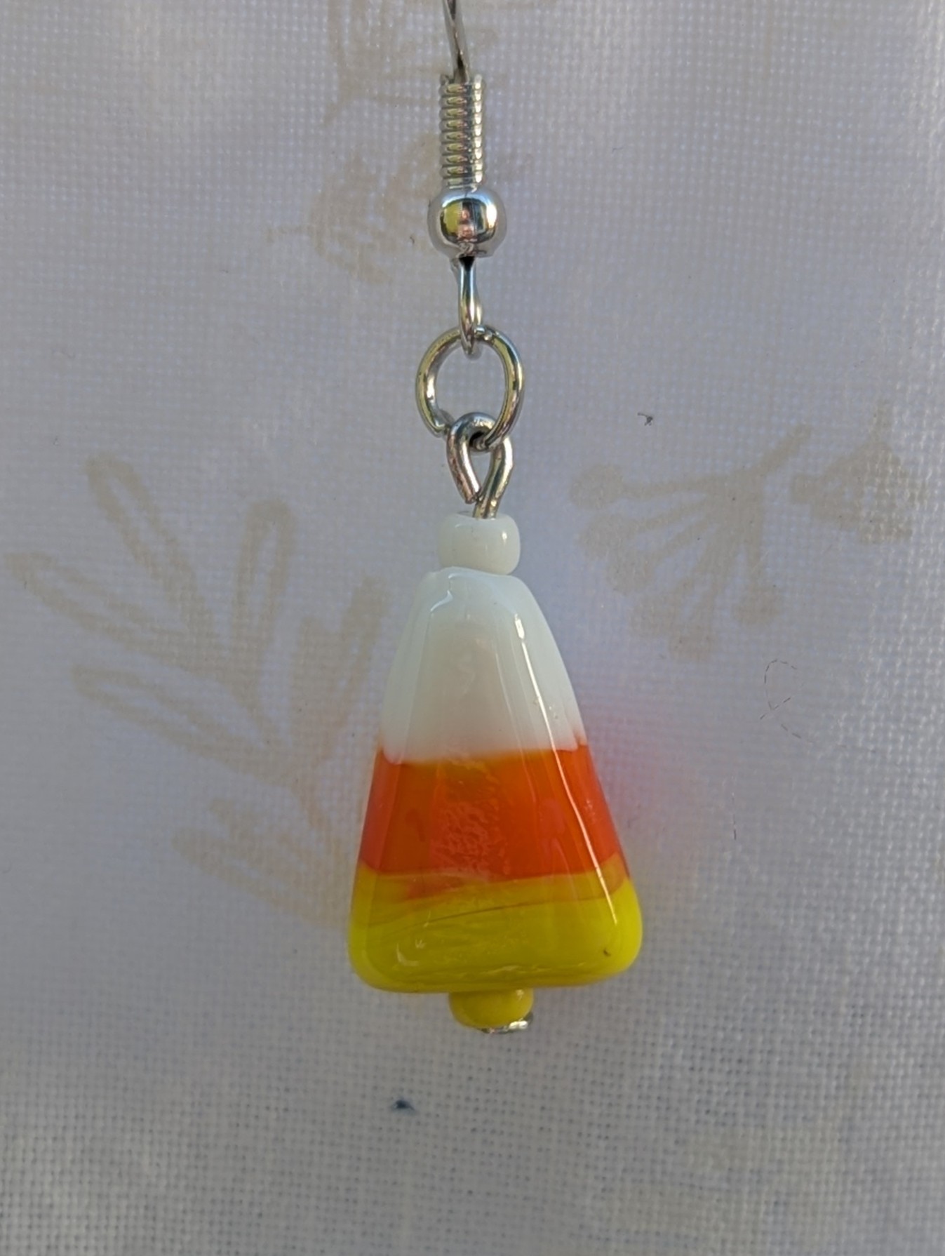 Candy corn glass Halloween earrings with yellow and white seed beads, sterling silver hooks, and silver jump rings for Halloween.