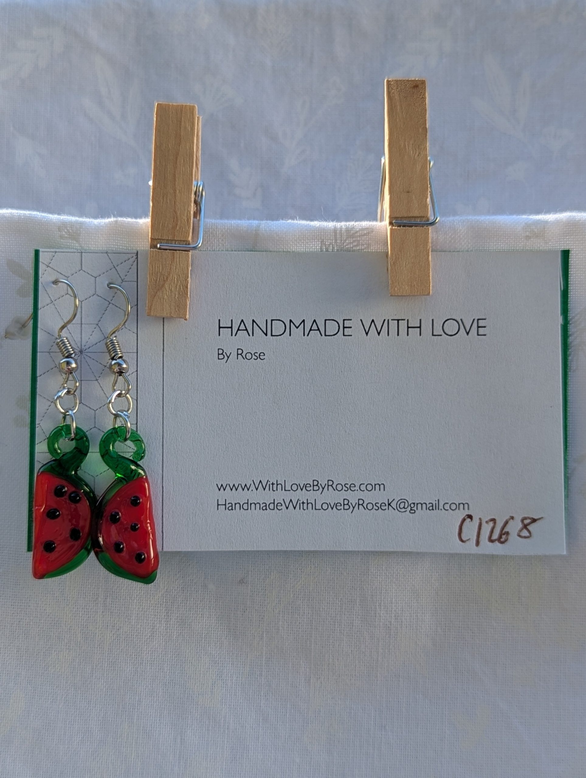 Handmade glass watermelon slice earrings with pink-red centers, green rinds, and sterling silver hooks.