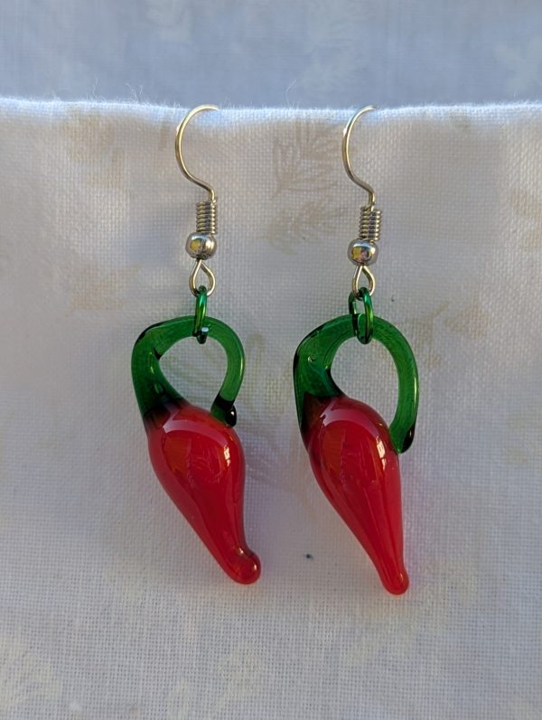 Handmade red pepper earrings featuring a single glossy red glass chili pepper bead with a green aluminum jump ring on steel hooks.