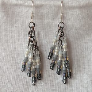 Handmade gradient beaded earrings with black-to-white ombre seed beads, tungsten connectors, and sterling silver hooks.