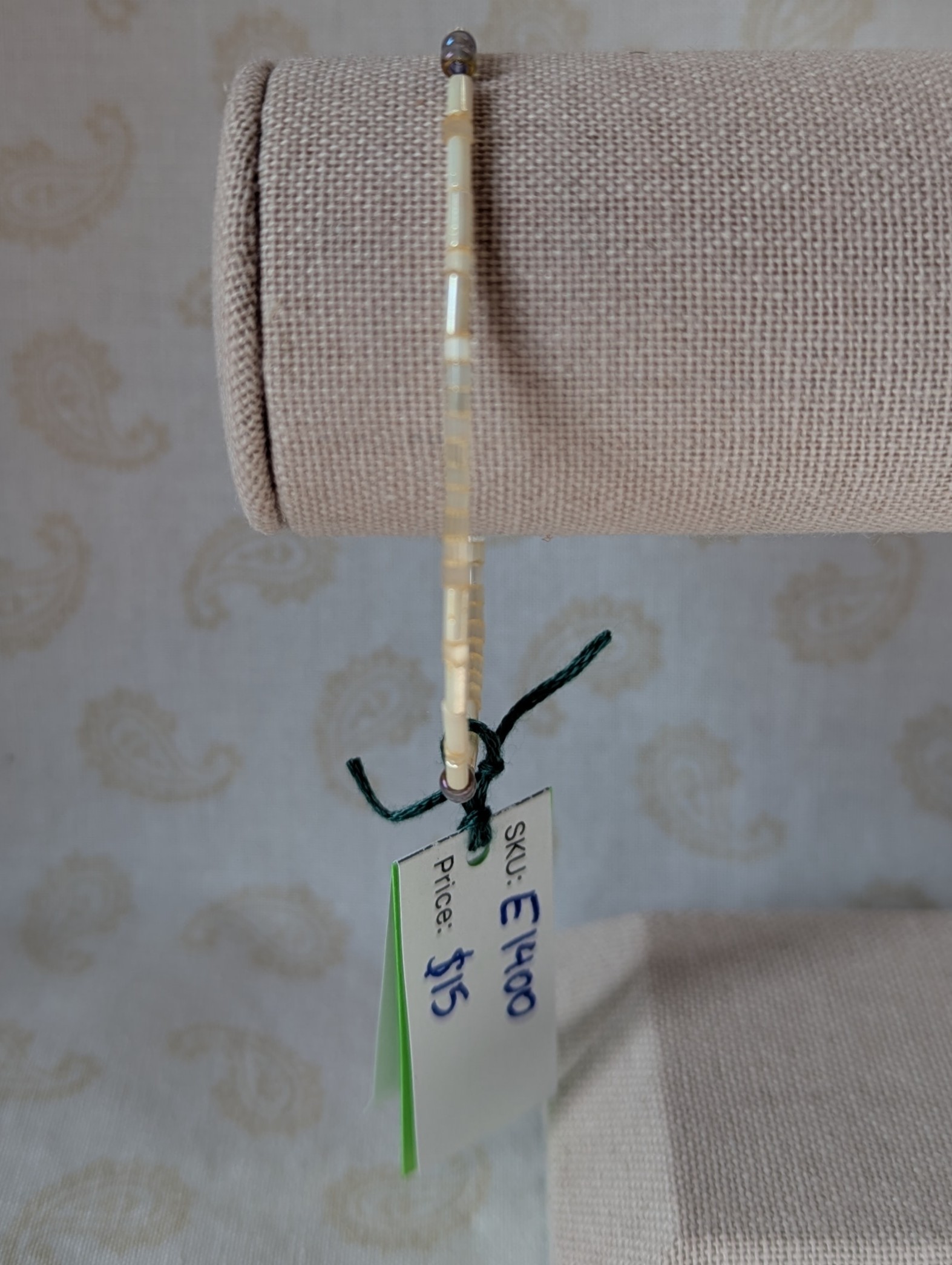 Handmade bracelet with short pearl-cream beads, long ivory-cream beads, and lavender-lined gray beads on silver-plated memory wire with a silver lobster clasp.