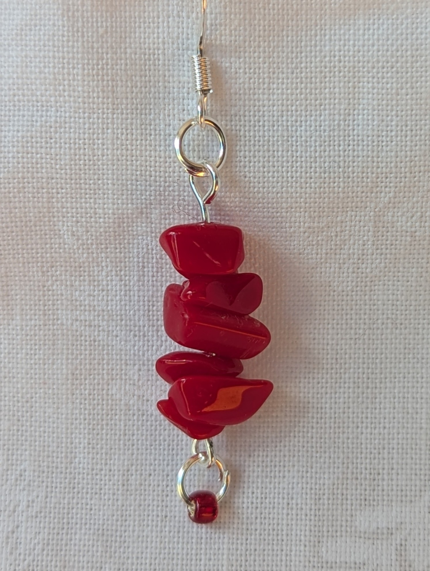 Handmade scarlet stone cascade earrings with red gemstone chips and small glass seed beads on sterling silver hooks.